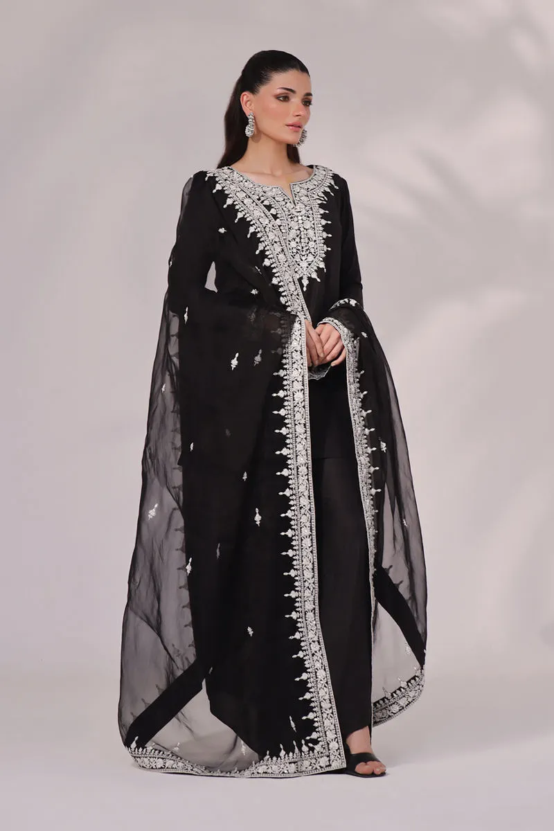 Model wearing the Inaya Black & White Raw Silk Set with mirror work, ideal for weddings, formal gatherings, and festive occasions. A perfect blend of traditional and modern elegance.