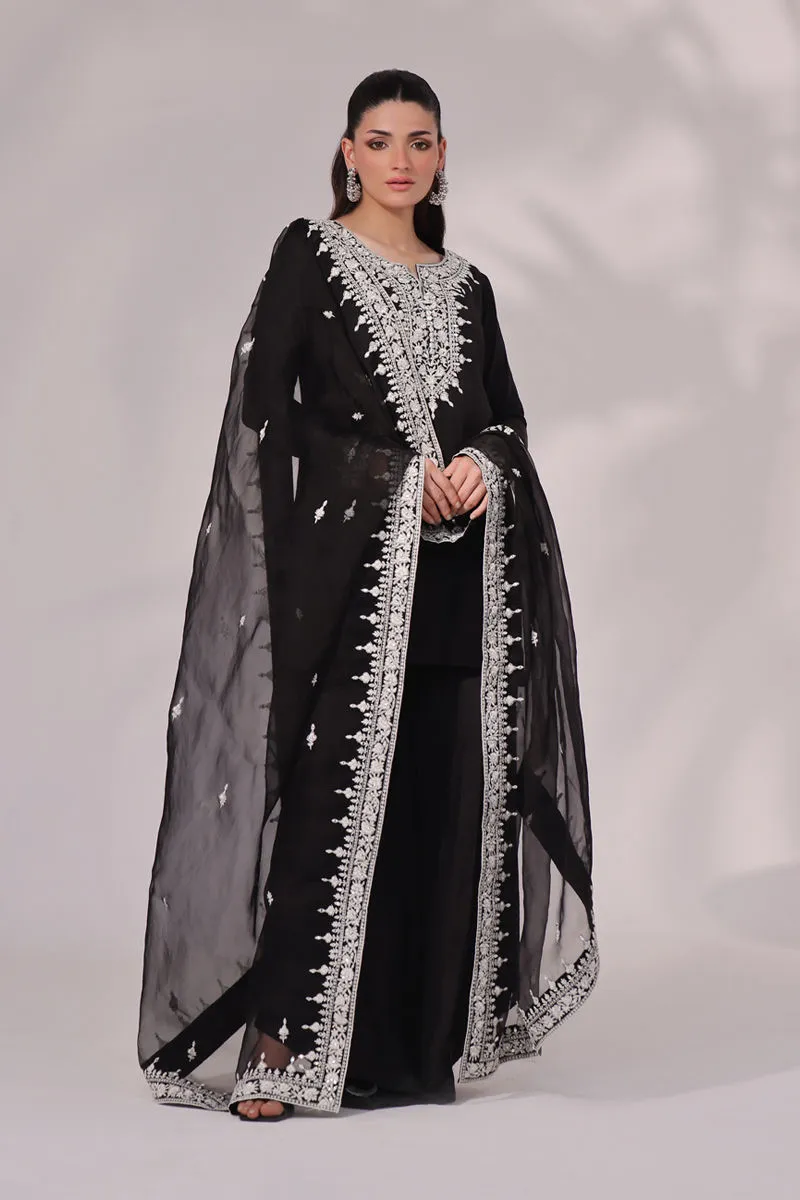 Back view of the Inaya Black & White Raw Silk Set, highlighting the luxurious fabric and elegant dupatta. The intricate embroidery and mirror work are a stunning feature."