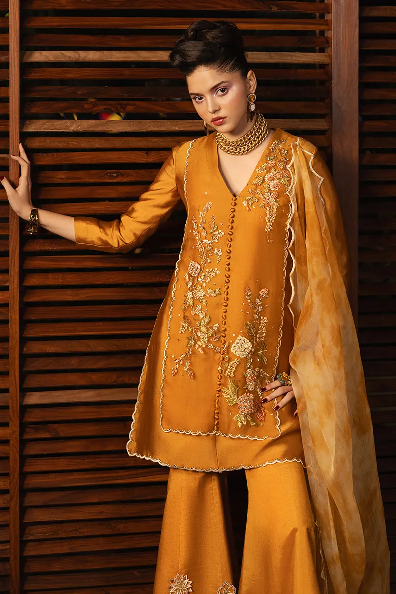 Close-up of the embroidered organza shirt with delicate floral motifs, showcasing the three-dimensional embroidery and loop button details.