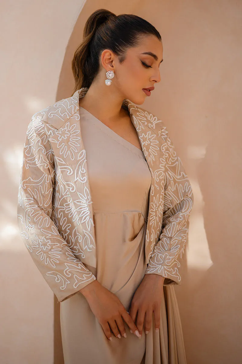 Refined tailoring highlighting the luxurious texture of the silk dress.