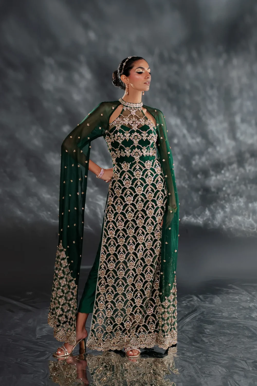 Emerald green dress with intricate crystal embellishments in a close-up shot.