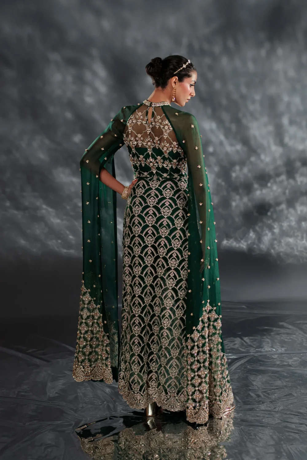 Emerald green dress with a flowing fabric, captured from the back.