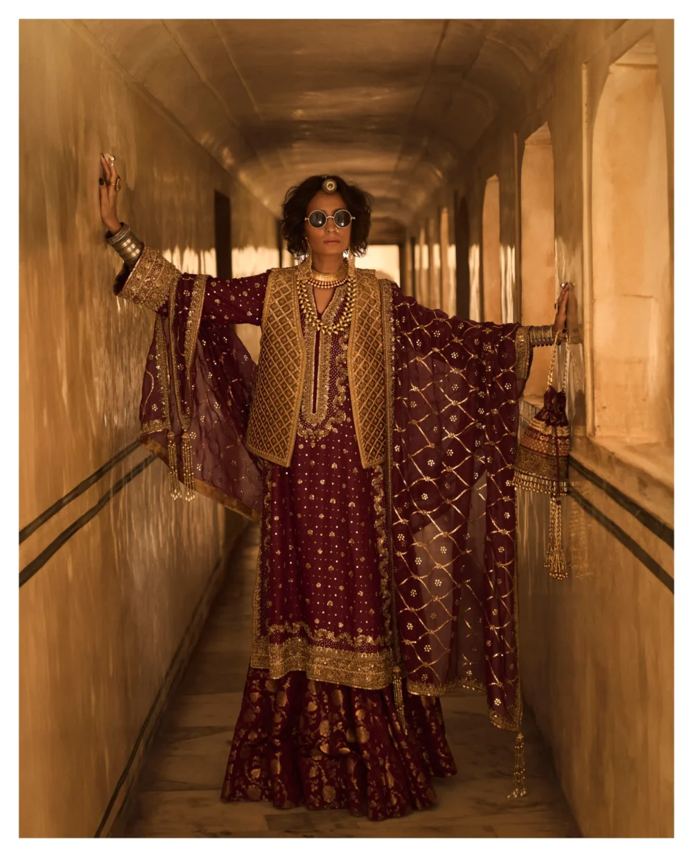 The intricate details of the Maroon Jamavar Lehenga Set are beautifully showcased as the model stands confidently.
