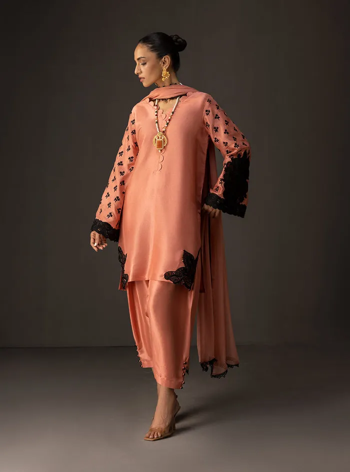 Full view of the coral embroidered suit, showcasing the contemporary silhouette and flowing chiffon dupatta.