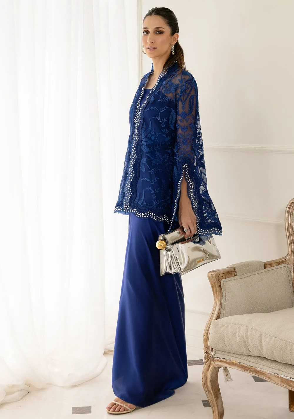 download (10) Model in royal blue organza cape and asymmetrical silk sarong skirt for a modern Eid 2026 glam look.