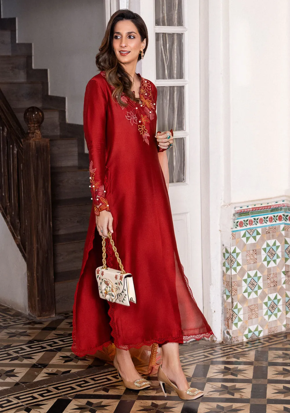 Close-up of floral cutwork on brick red sleeves and pearl accents for luxury Eid 2026 wear.