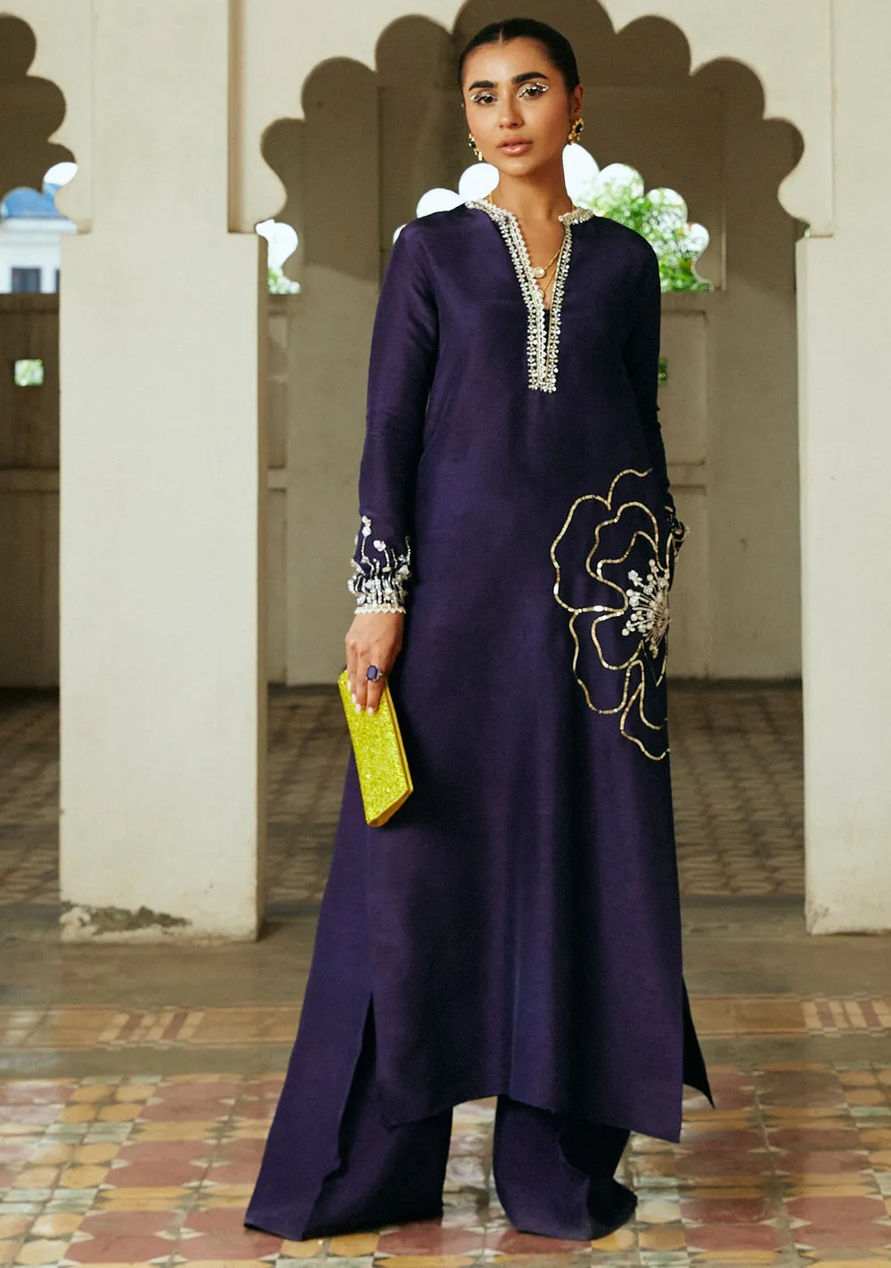 Model wearing Aubery eggplant column cut shirt and matching floor-length flared pants with pockets for Eid.