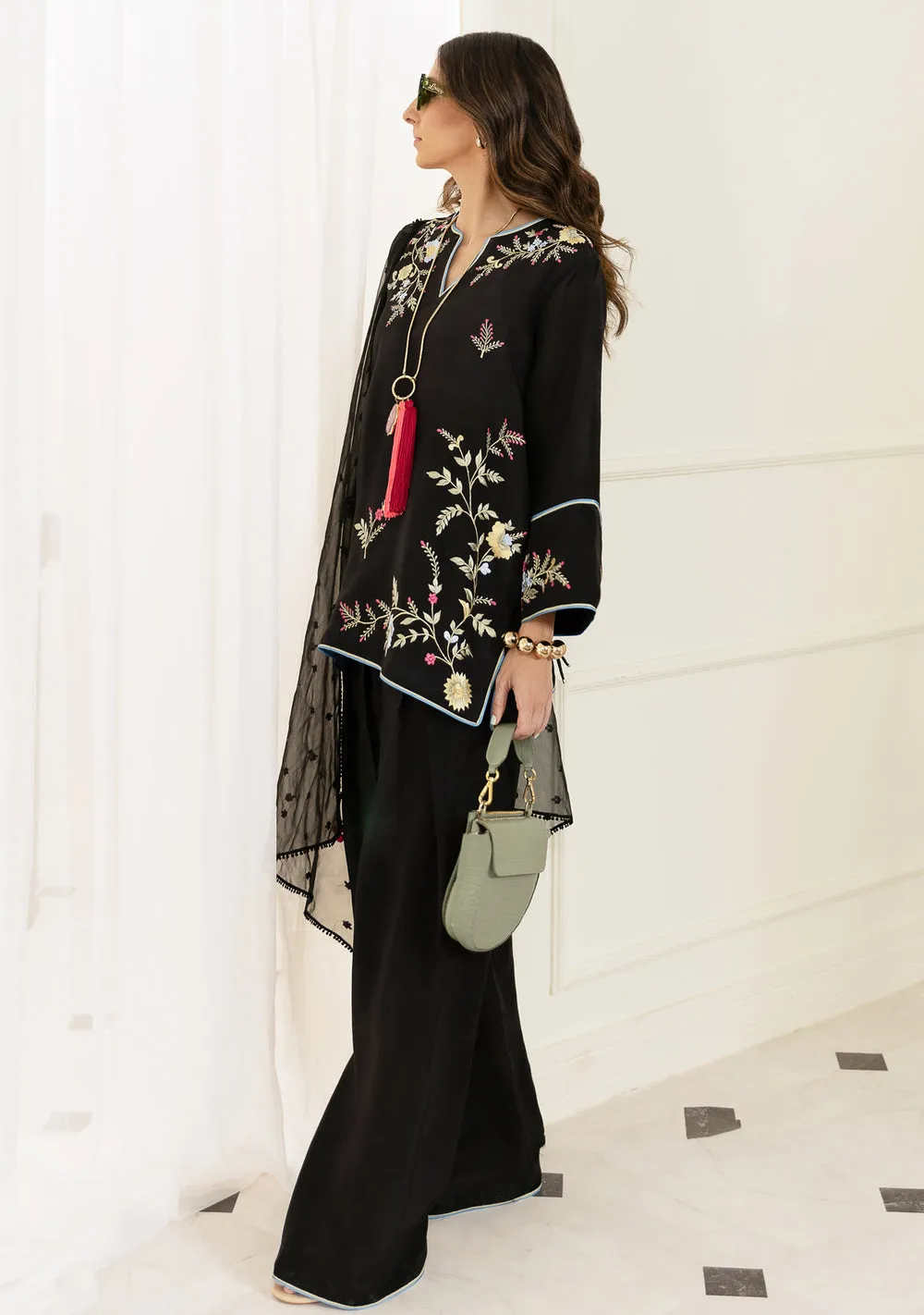 Rear view of Noirah black silk kurta showing colorful embroidered motifs and premium tassel silk texture.