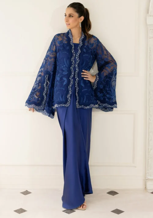 Model in royal blue organza cape and asymmetrical silk sarong skirt for a modern Eid 2026 glam look.